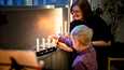 Pappi Kirsi Kniivilä ja 7-vuotias Leo Jokiniemi sytyttivät kynttilöitä Lasten kauneimmat joululaulut -tapahtumassa Vuoreksen seurakuntakodissa Tampereella sunnuntaina 19. joulukuuta.
