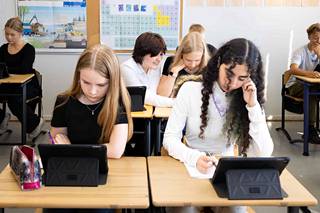 Kahdeksasluokkalaiset Julia Mattila ja Unna Hyvönen (takana keskellä) sekä Ella Lehtonen ja Shylee Shokrani tekivät matematiikan tehtäviä Ipadeilla Kaarilan koulussa.