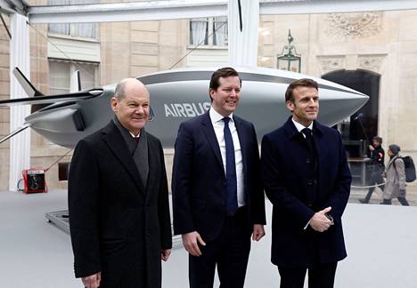 Saksan liittokansleri Olaf Scholz (vas.) ja Ranskan presidentti Emmanuel Macron poseerasivat Airbus-yhtiön puolustus- ja avaruusosaston johtajan Bruno Fichefeux’n kanssa Pariisissa sunnuntaina.