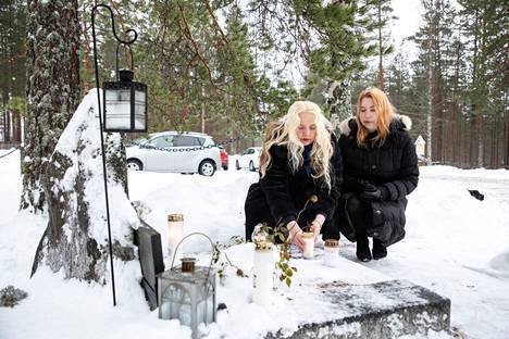 Liedenpohjan kyläyhdistyksen puheenjohtaja Pirjo Ala-Kaarre (vas) ja sihteeri Mea Matero kävivät laskemassa kynttilän perhesurmassa kuolleille Virtain Liedenpohjan kirkon hautausmaalla.