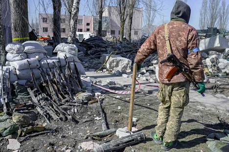 Venäjän tekemässä ohjusiskussa kuolleiden sotilaiden kiväärejä oli kerätty yhteen paikkaan eteläisen Ukrainan Mykolajivissa. Ukrainalaissotilas oli lauantaina vartioimassa aseita.