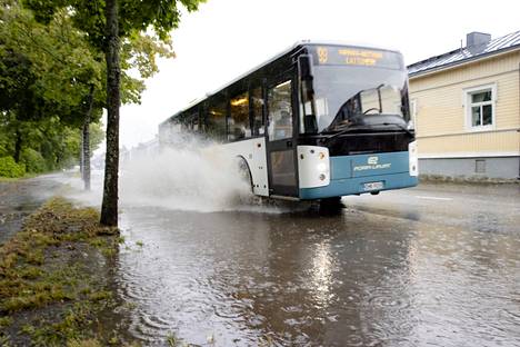Linja-auto piti matkantekijät kuivina paikoin tulvivalla Maantiekadulla. 