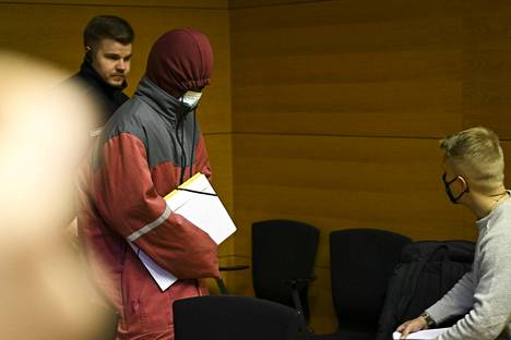 Syytetty peitti kasvonsa, kun hän saapui oikeuden istuntoon Helsingin käräjäoikeudessa torstaina 30. maaliskuuta.
