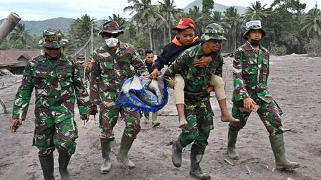 Pelastustyöntekijät kantavat turvaan Sumberwuluhin kylän asukasta Lumajangissa Semerun purkauksen jälkeen.