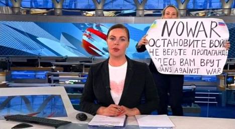 Kuvakaappaus Venäjän ykköskanavan lähetyksestä 15. maaliskuuta. Lähetyksen taustalla olevan tv-työntekijän käsissä on juliste, jossa lukee ”Ei sotaa. Lopettakaa sota, älkää uskoko propagandaa, täällä he valehtelevat teille. Venäläiset sotaa vastaan”.