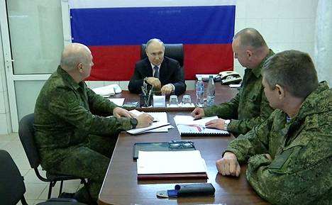Kuvakaappaus Kremlin julkaisemasta videosta esittää Putinin tapaamassa sotilaita.
