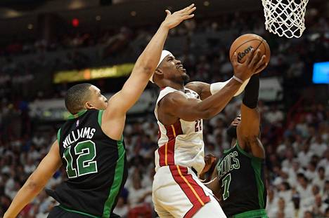 Miami Heatin Jimmy Butler (oik.) on heittämässä palloa koriin, Boston Celticsin Grant Williams yrittää estää. 