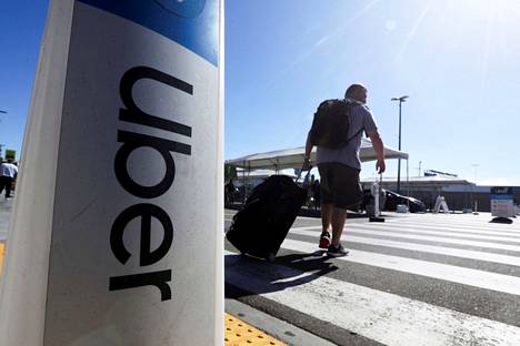 Matkustaja kävelee Uber-kyltin ohi saavuttuaan Los Angelesin kansainväliselle lentolentälle Yhdysvalloissa 10. heinäkuuta 2022. 