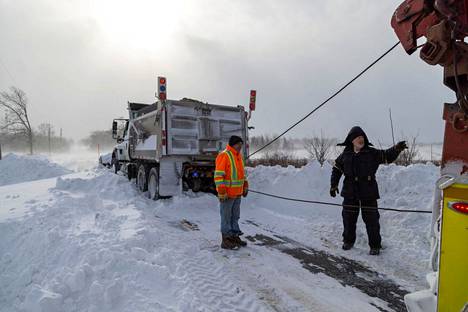 Kanadan puolella lumiaurakin tarvitsi hinausta. Larry Miskolczi (oikealla) auttoi lumiauran kuljettaja Gord Bartlettia Canfield Ontariossa. 