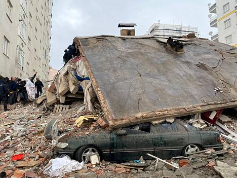 Pelastusviranomaiset yrittävät etsiä eloonjääneitä romahtaneiden rakennusten raunioista.