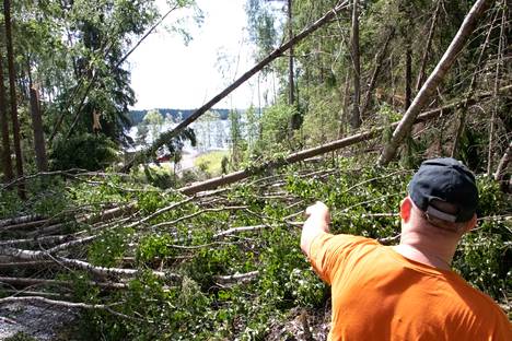 Jussi Järvinen esittelee mökkitielle kaatuneita puita Inkulassa Viljakkalassa.