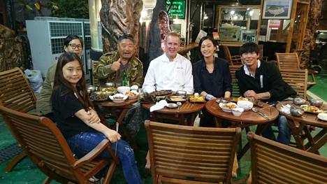 Reissukuva. Antila ruokailemassa etelä-korealaisen ravintoloitsijaperheen kanssa.