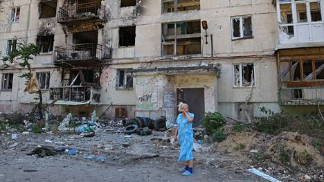 Nainen pyyhki kasvojaan pahoja tuhoja kärsineen talon edustalla Luhanskin Severodonetskissa. Kuukausia kestäneet raskaat taistelut päättyivät kaupungissa juhannuksen tienoilla ukrainalaisjoukkojen vetäytymiseen. 