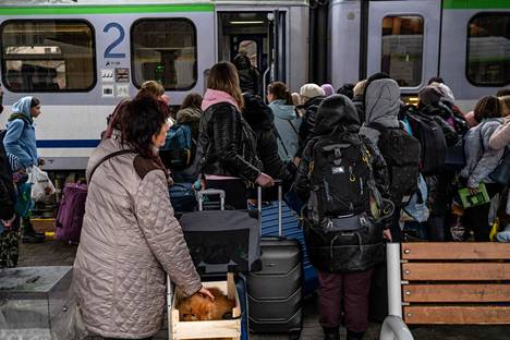 Ukrainasta tulleita pakolaisia nousee junaan Przemyslin rautatieasemalla Kaakkois-Puolassa lähellä Puolan ja Ukrainan rajaa 1.4.2022.