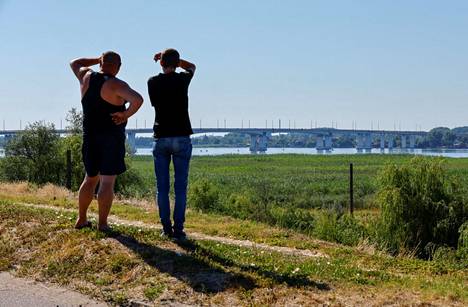 Miehet katsovat Antonivskyin siltaa.