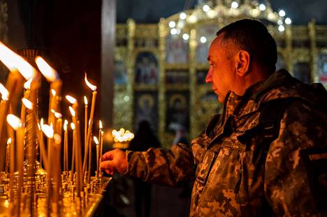 Maastopukuinen kävijä sytytti kynttilän lauantaina Žytomyrissa Ukrainassa.