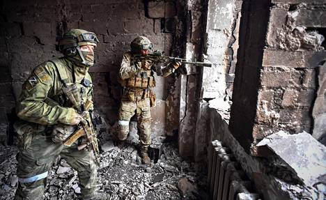Venäläissotilaat partioivat Mariupolin tuhoutuneessa teatterirakennuksessa tiistaina.
