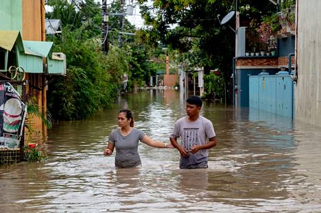 Tulvavesi ulottui ihmisiä miltei vyötäisille Filippiinien Kawitin kylässä sunnuntaina 30. lokakuuta.