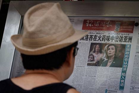 Pekingiläinen lukee Global Times -sanomalehden artikkelia Pelosin Aasian-kiertueesta maanantaina 1. elokuuta 2022. Jutun otsikossa lukee: Pelosi vierailee Aasiassa ruudinhajuisena. 