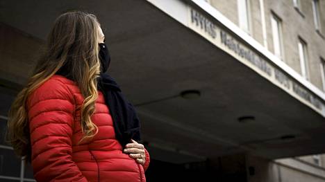 Kasvomaskia käyttävä raskaana oleva nainen Naistenklinikan edustalla.
