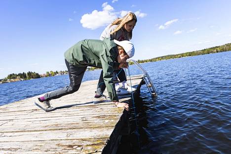 Nicholas Pekkinen ja Tinja Virtanen mittaavat veden näkösyvyyttä secchi-levyllä. Näkyvyys ulottui laiturin nokassa 140 senttimetriin.