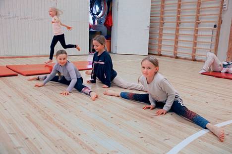 Vilhelmiina Kärkkäinen, Emma Uusi-Rantala ja Katri Välineva tekevät spagaatin suorastaan kadehdittavan helposti. Taustalla juoksee Helmi Peräaho.
