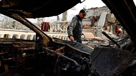 Palestiinalaismies tutkii Israelin ilmaiskun tuhoamaa autoa Rafahissa eteläisessä Gazassa 26. maaliskuuta.