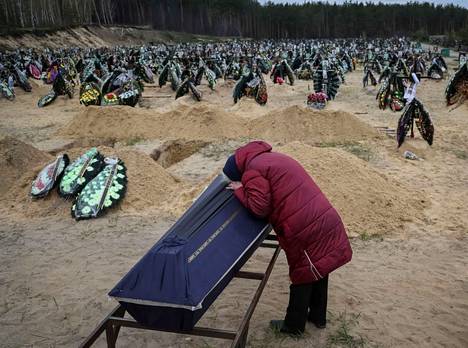 Ukrainalaisnainen suri venäläisjoukkojen tappamaa sukulaistaan Irpinin hautausmaalla Kiovan alueella.
