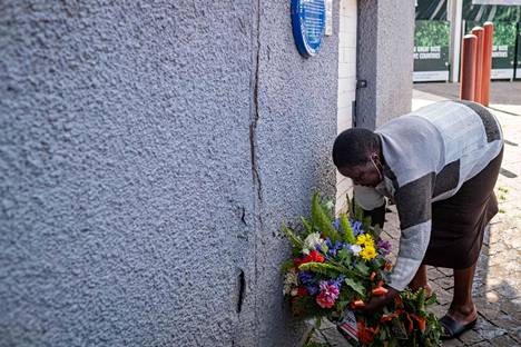 Rouva kävi viemässä kukkia sunnuntaina kuolleen Desmond Tutun kotitalon ulkopuolelle.