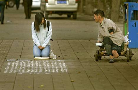 Nuori nainen yrittää ansaita rahaa isänsä sairaalakuluihin kirjoittamalla tarinaansa liidulla jalkakäytävän pintaan Tayuan kaupungissa Kiinassa.