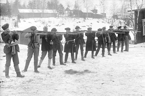 Punakaarti ampuma-harjoituksissa Siltalan talon pihalla Ruovedellä. Kaartilaiset olivat kokemattomia aseiden kanssa ja opettelivat ampumaan ennen rintamalle lähtöä.