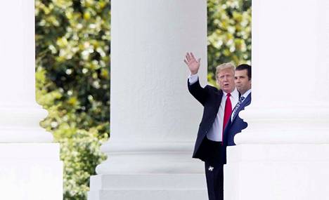 Presidentti Donald Trump ja hänen poikansa Donald Trump Jr. heiluttelivat kuvaajille Valkoisen talon pylväikön takaa heinäkuussa.
