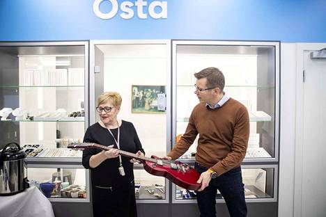 Sirpa Virtanen ja Marko Immonen tutkivat kitaraa, jonka hinta panttilainaamossa on yli 500 euroa. Helsingin Pantin Porin-toimipisteessä on myynnissä soittimien lisäksi paljon erityisesti koruja.