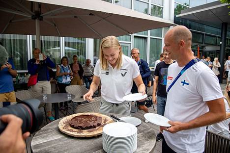 Wilma Murto leikkasi kakkua valmentajansa Jarno Koivusen kanssa.