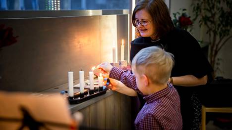 Pappi Kirsi Kniivilä ja 7-vuotias Leo Jokiniemi sytyttivät kynttilöitä Lasten kauneimmat joululaulut -tapahtumassa Vuoreksen seurakuntakodissa Tampereella sunnuntaina 19. joulukuuta.