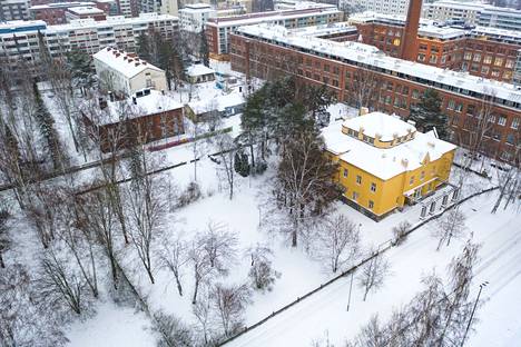 Tampereen Pyynikillä keltaisen De Gamlas Hem -rakennuksen yllä kuvattiin joulukuussa 2021. Taustalla näkyy valkoinen vanha kulkutautisairaala. 