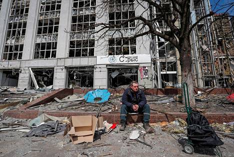 Mies istui tuhoutuneen talon edessä Mariupolissa 10. huhtikuuta. ALEKSANDR JERMOTŠENKO / REUTERS
