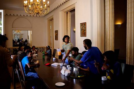 Mielenosoittajat söivät aamupalaa vallatun presidentin talon kokoussalissa torstaina. Mielenosoittajat ilmoittivat lähtevänsä rakennuksista pois.