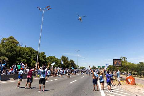 Fanit tervehtivät MM-kultajoukkueen pelaajia kuljettanutta helikopteria Buenos Airesin esikaupunkialueella. Pelaajat siirrettiin busseista helikoptereihin, koska mestareita kuljettaneet bussit eivät päässeet keskustaan.
