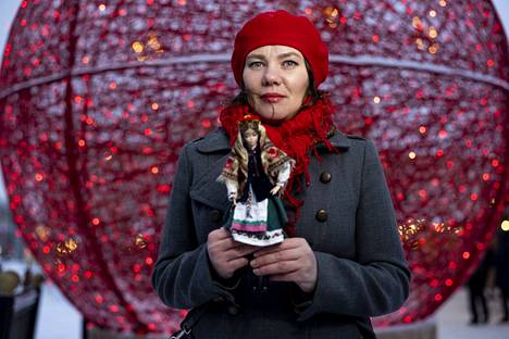 Maryna Sokolenkolla on kädessään ukrainalaiseen asuun puettu Barbie-nukke. Kuvassa Sokolenko on Tampereen Joulutorilla.