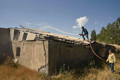 Palomiehet ruiskuttivat keskiviikkona vettä talon raunioihin Sotkissa Armeniassa. Talon kerrottiin vaurioituneen Azerbaidžanin tykistötulessa.