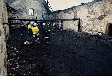 Näky tulipalon jälkeen järkytti. Palomiehet kantoivat hiiltyneitä rakenteita ulos aamulla palaneesta kirkosta 21. syyskuuta 1997.