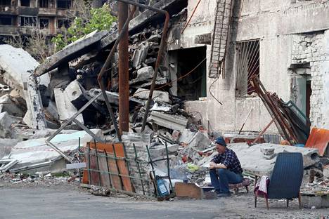 Mies istui tuhoutuneen talon edessä Mariupolissa, Ukrainan eteläisessä satamakaupungissa, jota on pommitettu ja saarrettu koko Venäjän hyökkäyksen ajan.