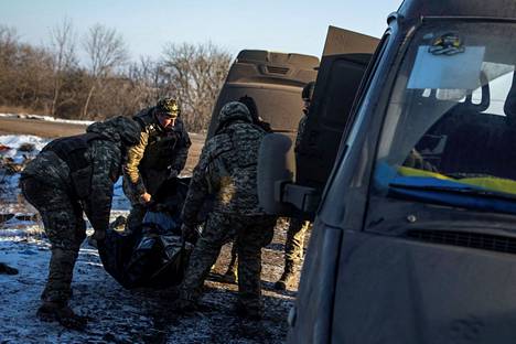 Ukrainalaiset sotilaat kantoivat tulitaistelussa menehtynyttä ruumista autoon lähellä taisteluiden etulinjaa Donetskin alueella keskiviikkona 8. helmikuuta.