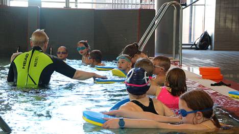 Uimakoululaiset harjoittelevat liukumista Marika Kallion opastuksessa.