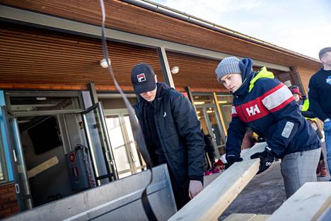 Oppilaat Tuomas Javanainen ja Sakari Harjunpää osallistuivat lahjoituksena saatujen kuusilautojen kantamiseen peräkärrystä koulun teknisen työn tiloihin. 9A-luokan haaveissa on päästä myyjäisillä ja linnunpöntöillä kerätyillä varoilla luokkaretkelle.