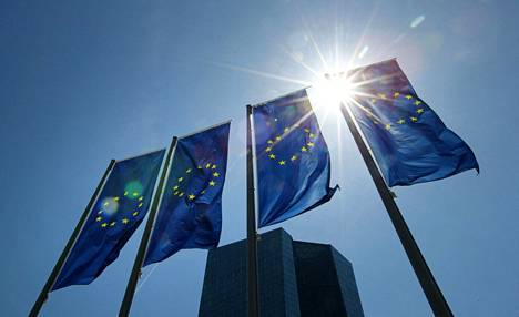 EU:n liput liehuvat Euroopan keskuspankin päämajan edustalla Frankfurt am Mainissa. Keskuspankin odotetaan nostavan ohjauskorkoaan ensimmäistä kertaa vuosiin.