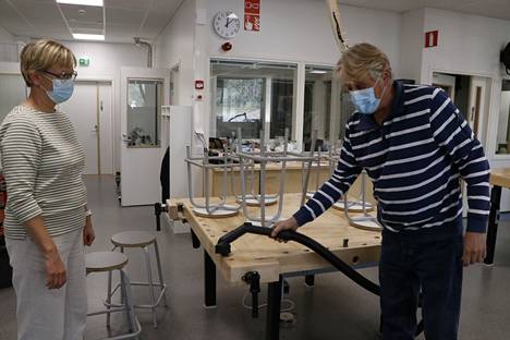 Apulaisrehtori Heikki Kangasluoma näyttää rehtori Katri Rantalalle, kuinka jäljet siivotaan imurilla heti työskentelyn jälkeen.