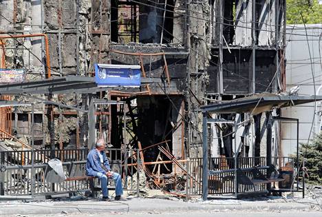 Mies istui tuhotun rakennuksen edustalla Mariupolissa Ukrainassa 9. toukokuuta.