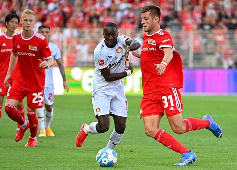Union Berlinin Robin Knoche (oik) and Leverkusenin Moussa Diaby kamppailivat tiukasti pallosta.
